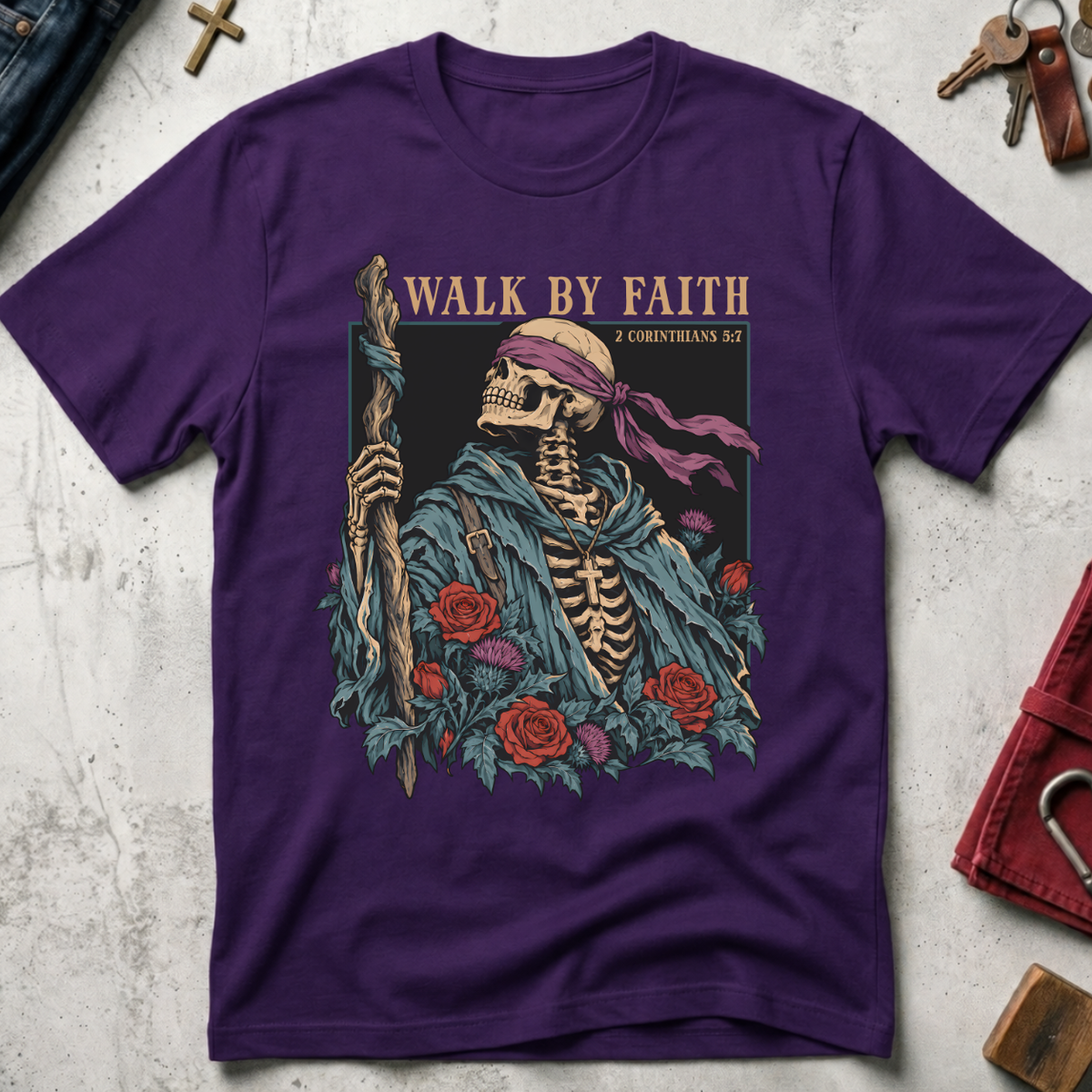 Walk by Faith Christian T-shirt in Purple with a gothic skeleton pilgrim, wooden staff, cross necklace, roses and thistles.